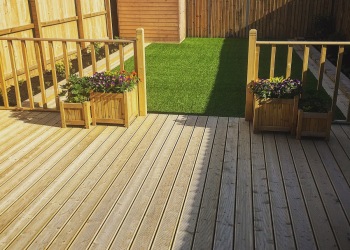 Brand new decking and artificial grass played in new build house's back garden. This image was taken on a mobile device